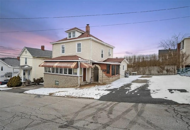 traditional style home with driveway and a chimney