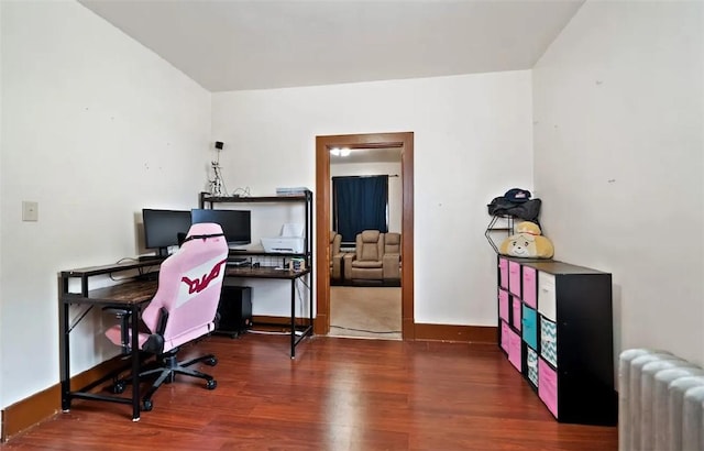 office with radiator heating unit, wood finished floors, and baseboards