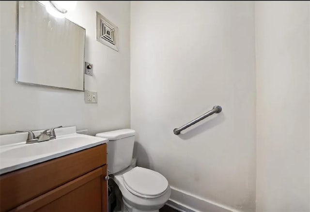 bathroom with vanity, toilet, and baseboards