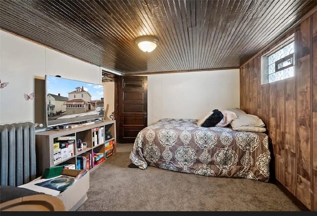 carpeted bedroom featuring wood ceiling, radiator, and wooden walls