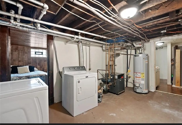 below grade area featuring a heating unit, washer and clothes dryer, and gas water heater