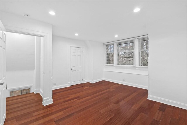 unfurnished room with baseboards, dark wood-type flooring, and recessed lighting