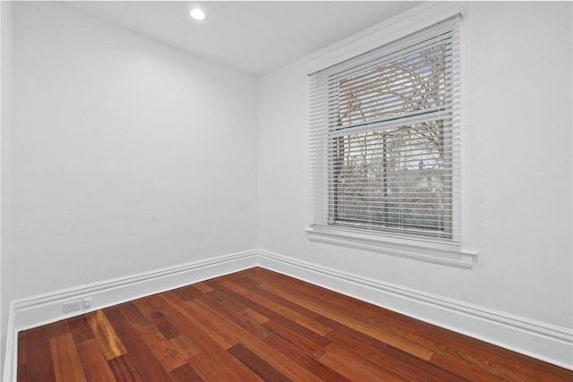 empty room featuring recessed lighting, baseboards, and wood finished floors