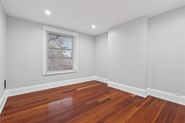 unfurnished room featuring baseboards, wood finished floors, and recessed lighting