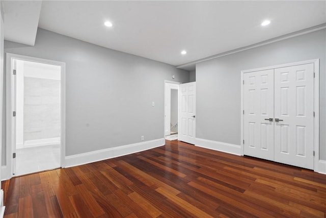 unfurnished bedroom featuring recessed lighting, dark wood-style flooring, ensuite bath, and baseboards