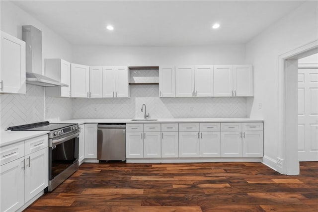 kitchen with sink, dark wood-type flooring, stainless steel appliances, white cabinets, and wall chimney exhaust hood