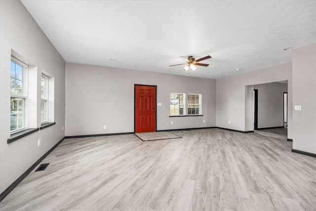 empty room with ceiling fan and light hardwood / wood-style floors