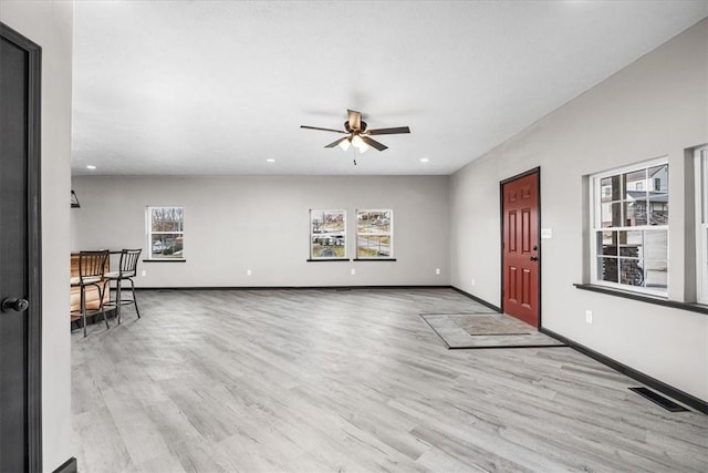 unfurnished living room with ceiling fan, plenty of natural light, and light wood-type flooring