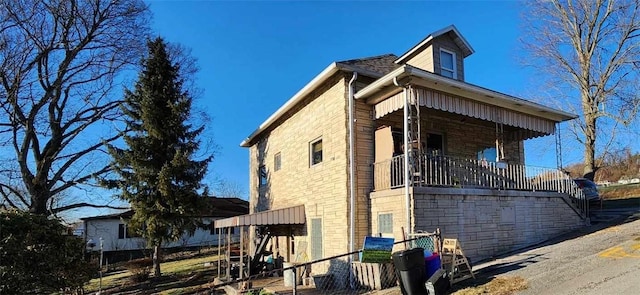 view of side of property featuring covered porch