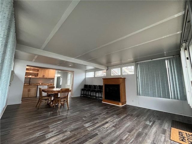 dining space with dark hardwood / wood-style floors and vaulted ceiling with beams