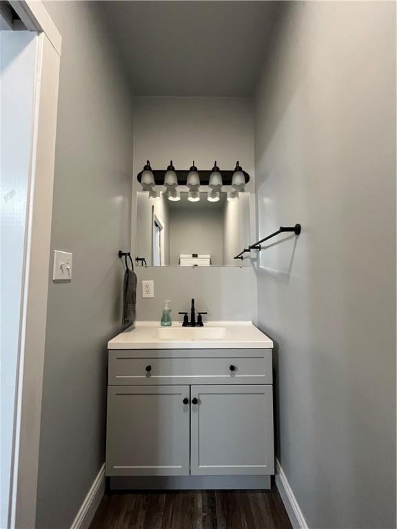 bathroom with wood finished floors, vanity, and baseboards