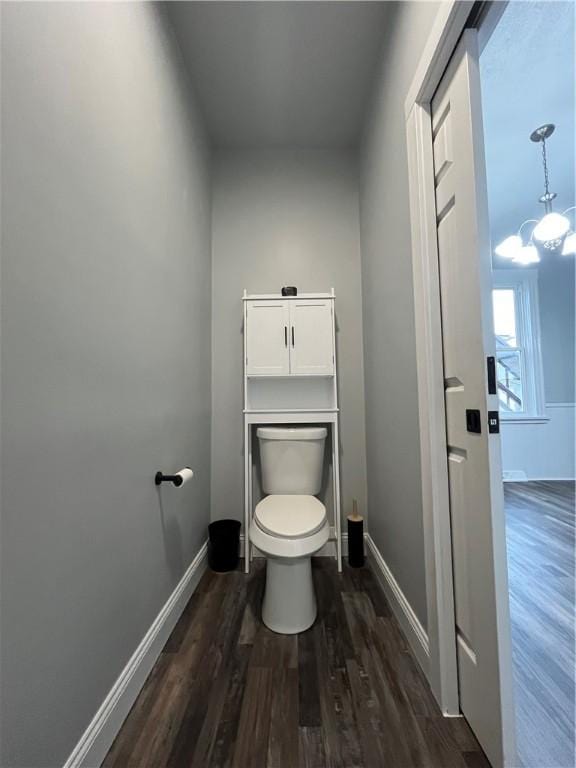 bathroom with hardwood / wood-style flooring, a chandelier, and toilet