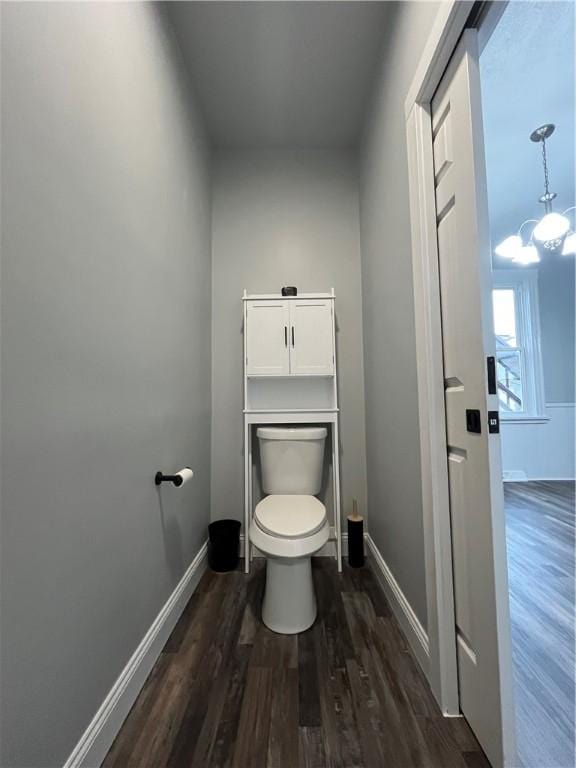 bathroom featuring toilet, a notable chandelier, wood finished floors, and baseboards