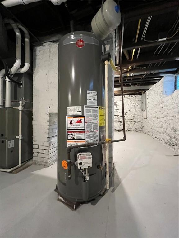 utility room featuring heating unit and gas water heater