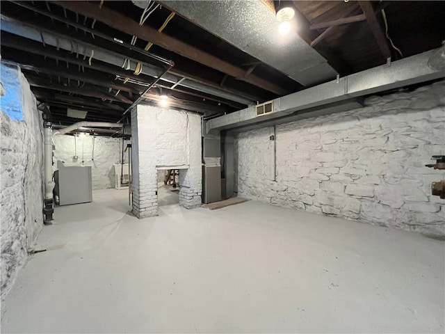 unfinished basement with visible vents and washer / clothes dryer