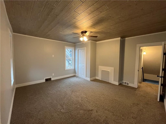 empty room with dark colored carpet, crown molding, ceiling fan, and wood ceiling