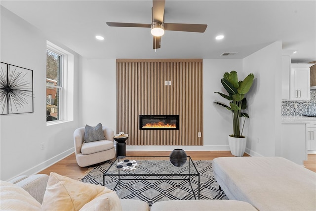 living room with ceiling fan and light wood-type flooring