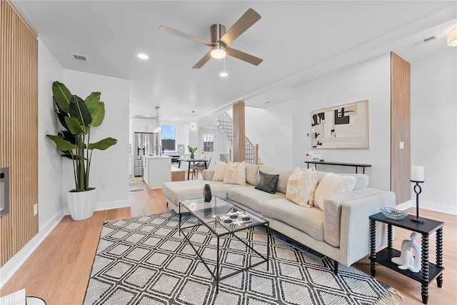 living room featuring ceiling fan and light hardwood / wood-style flooring