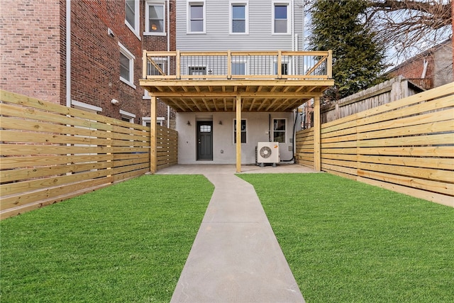 rear view of house with ac unit, a yard, a deck, and a patio area