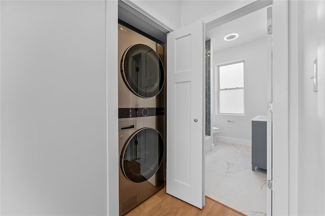 clothes washing area featuring stacked washing maching and dryer