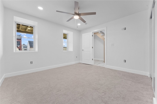 empty room featuring ceiling fan and light carpet