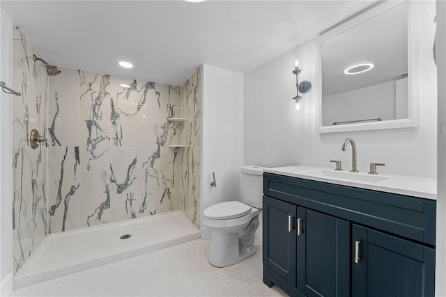 bathroom with vanity, tiled shower, and toilet