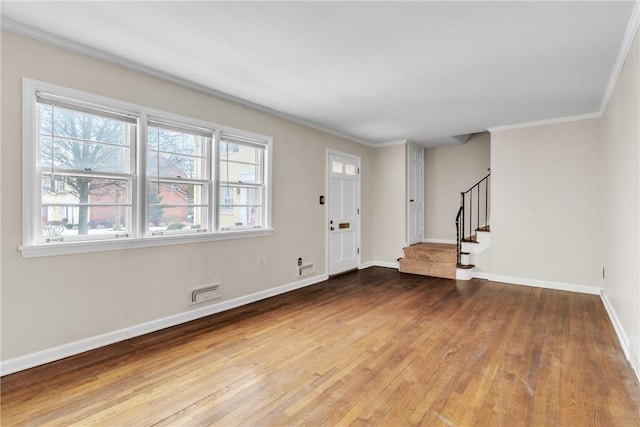 foyer entrance with crown molding and hardwood / wood-style floors