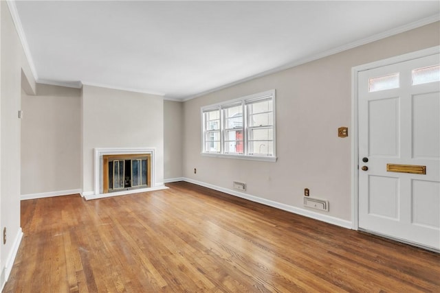 unfurnished living room featuring crown molding and light wood-type flooring