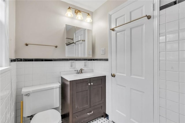 bathroom featuring vanity, tile walls, and toilet