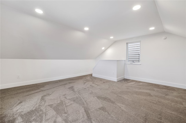 bonus room with vaulted ceiling and carpet floors