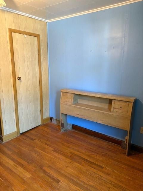 unfurnished bedroom featuring ornamental molding and dark hardwood / wood-style flooring