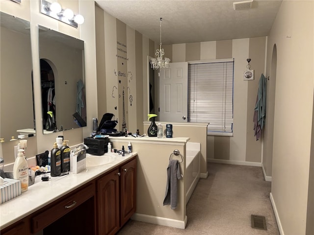 bathroom with a washtub, vanity, and a textured ceiling