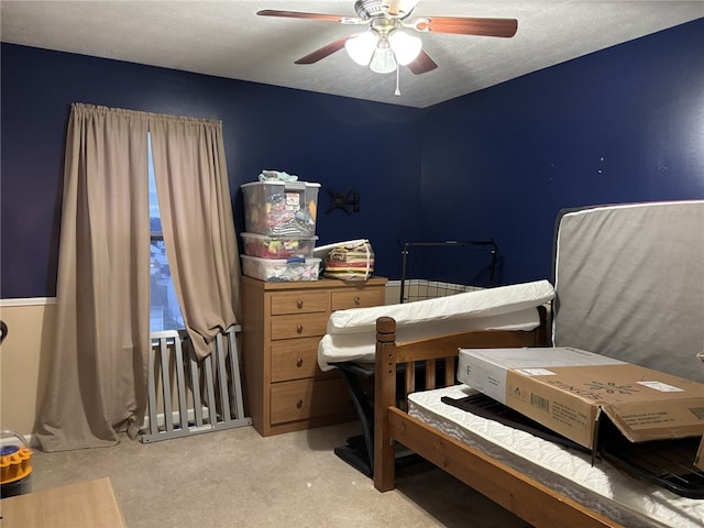 bedroom with ceiling fan, light carpet, and a textured ceiling