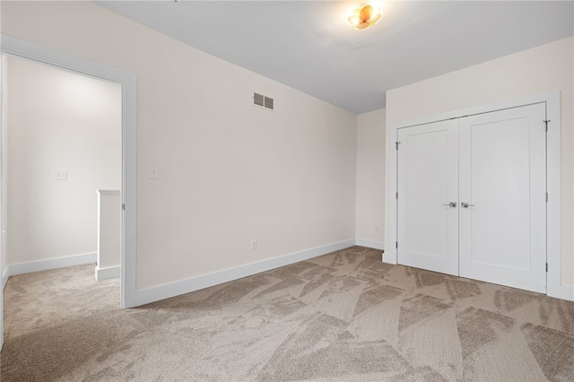 unfurnished bedroom featuring a closet and light carpet