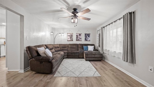 living room featuring light hardwood / wood-style flooring and ceiling fan