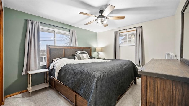 bedroom with multiple windows, light colored carpet, and ceiling fan