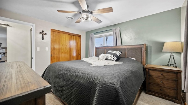 bedroom with light colored carpet, a barn door, and ceiling fan