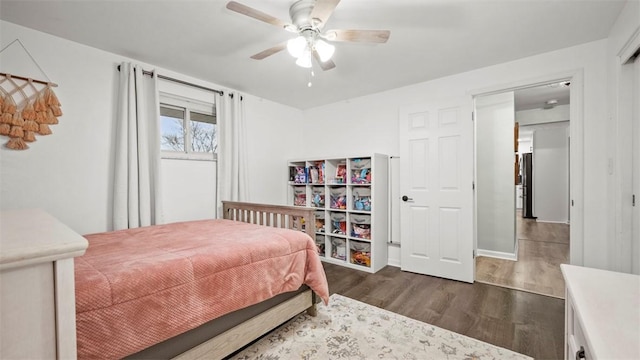 bedroom with fridge, dark hardwood / wood-style floors, and ceiling fan