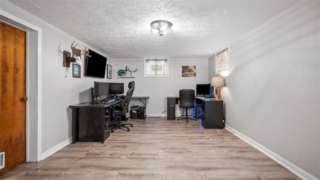 office space featuring a textured ceiling and light wood-type flooring