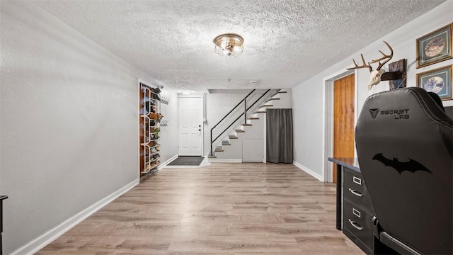 interior space with a textured ceiling and light wood-type flooring