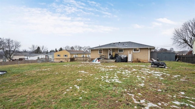 rear view of property with a storage shed and a lawn