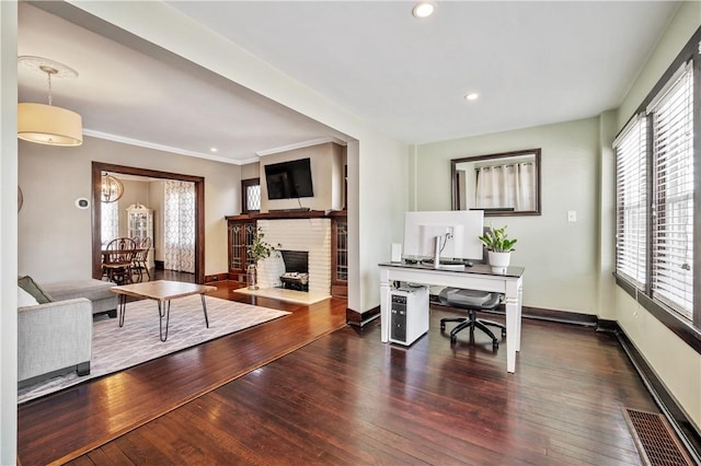 home office with dark wood-type flooring, ornamental molding, a fireplace, and baseboard heating