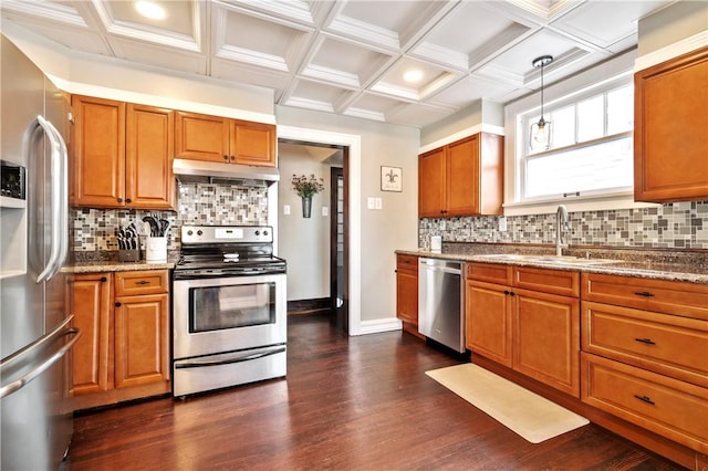 kitchen with pendant lighting, sink, stainless steel appliances, dark hardwood / wood-style floors, and light stone counters