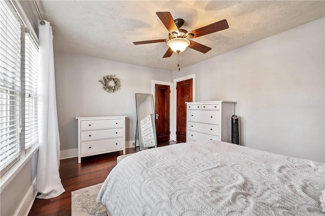 bedroom with multiple windows, ceiling fan, dark hardwood / wood-style floors, and a textured ceiling