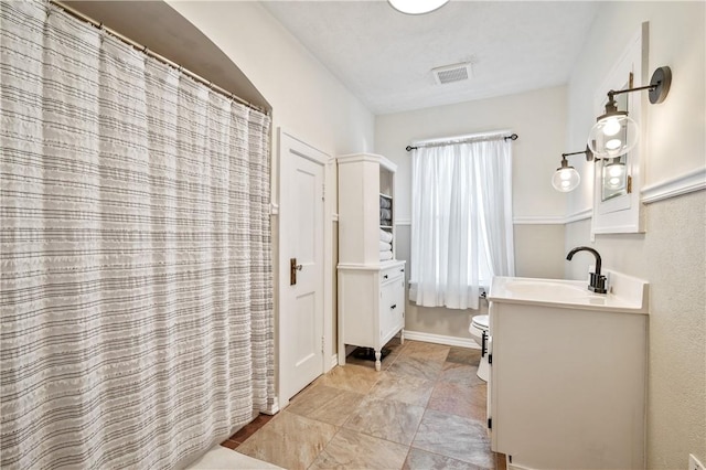 bathroom featuring vanity and toilet