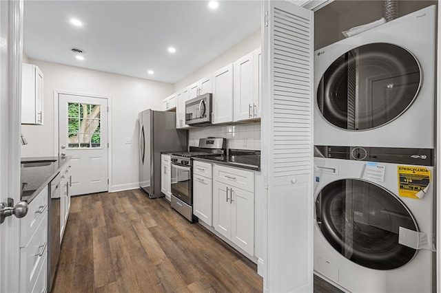 washroom featuring stacked washer / drying machine, sink, and dark wood-type flooring