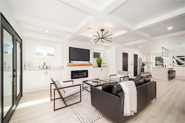 living room featuring coffered ceiling, light hardwood / wood-style floors, and beamed ceiling