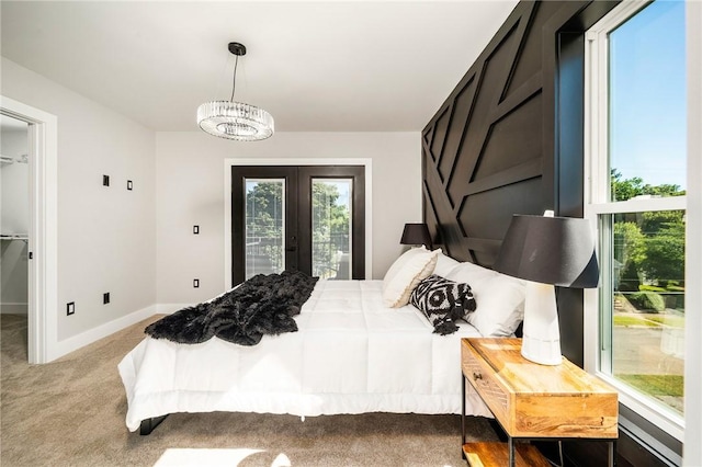 carpeted bedroom featuring french doors, a notable chandelier, and access to outside