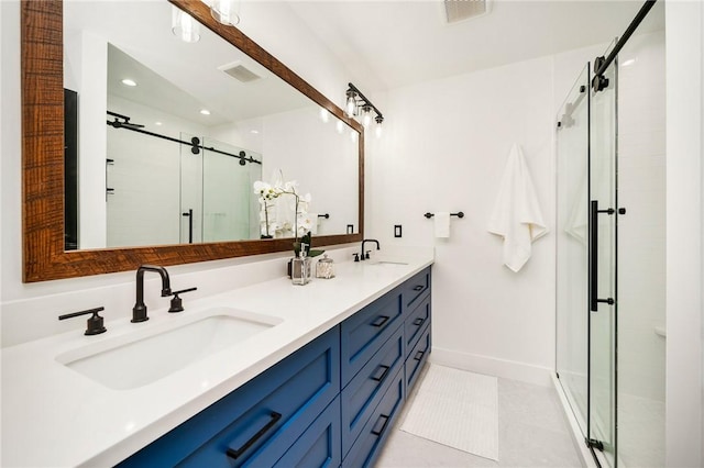 bathroom featuring a shower with door, vanity, and tile patterned floors