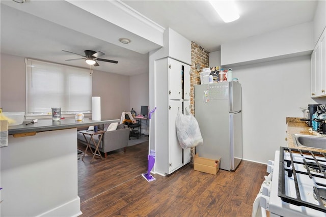 kitchen featuring dark wood-type flooring, ceiling fan, fridge, white cabinets, and white gas range